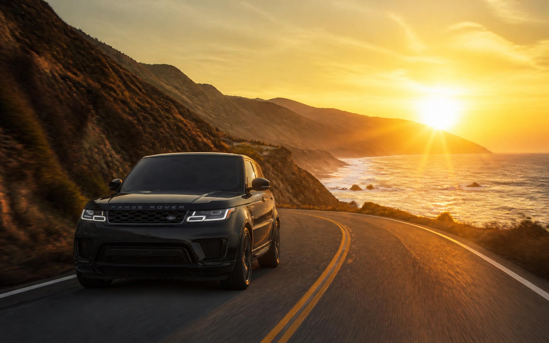Black Range Rover on a coastal highway at golden hour